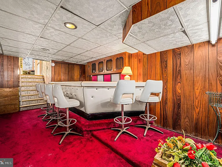 Philly home of boxer Muhammad Ali and family, midcentury modern home interior with basement bar and red carpet in Morris Park Philadelphia