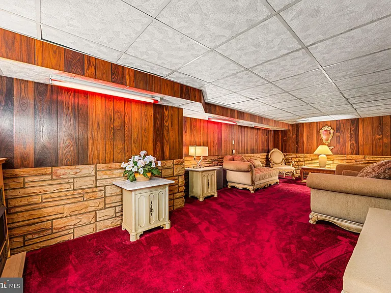 Philly home of boxer Muhammad Ali and family, midcentury modern home interior with basement bar and red carpet in Morris Park Philadelphia