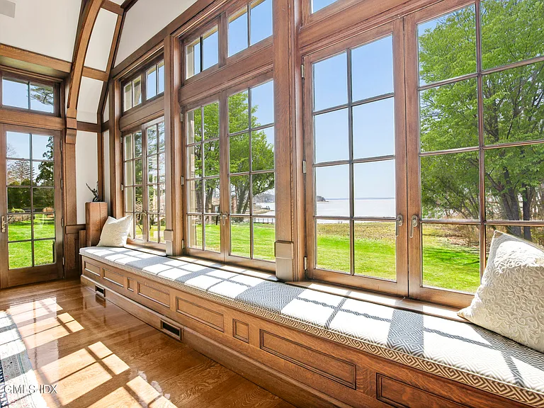 Massive Long Island Sound Mansion, interior of Cedarcliff Road in Riverside Connecticut with sun-drenched window seats in rich natural wood