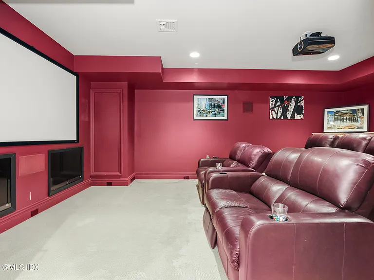 Massive Long Island Sound Mansion, interior of Cedarcliff Road in Riverside Connecticut with home theater in dark red and burgundy hues