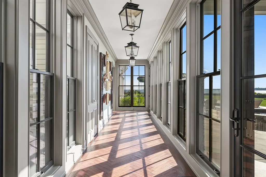 Most expensive house in Rhode Island, interior of 441 West Main Road in Little Compton with sun drenched glass corridor overlooking the Atlantic Ocean