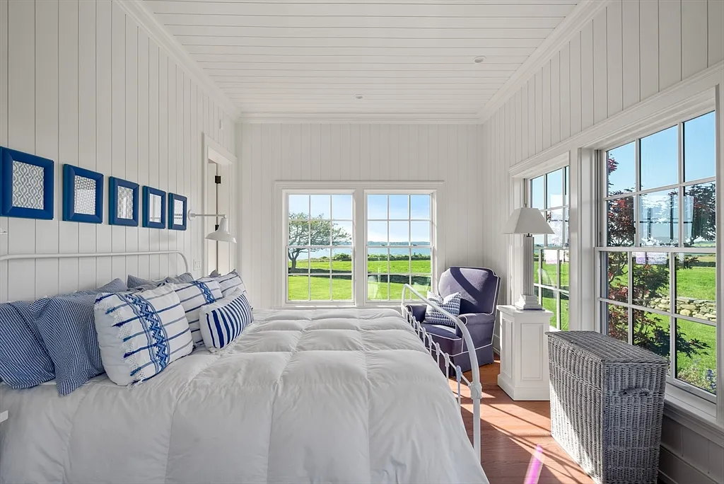 Most expensive house in Rhode Island, interior of 441 West Main Road in Little Compton with sun drenched master bedroom in white and blue hues