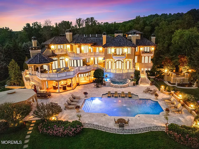 Massive Tuscan Palace in New Jersey on the Rumson and Navasink Rivers, exterior at night overlooking the in ground pool and rumson river