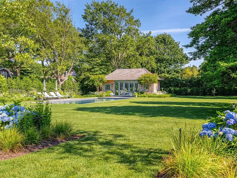 Old money Hamptons estate 134 Herrick Rd in Southampton New York, exterior pool house with lush landscape views