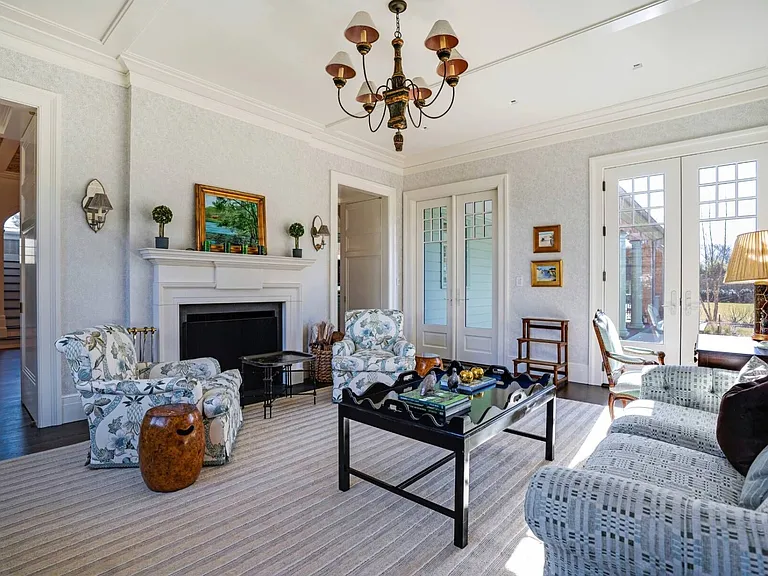 Old money Hamptons estate 134 Herrick Rd in Southampton New York, interior sitting and sun room with vaulted ceilings and floral furnishings a la coastal grandma