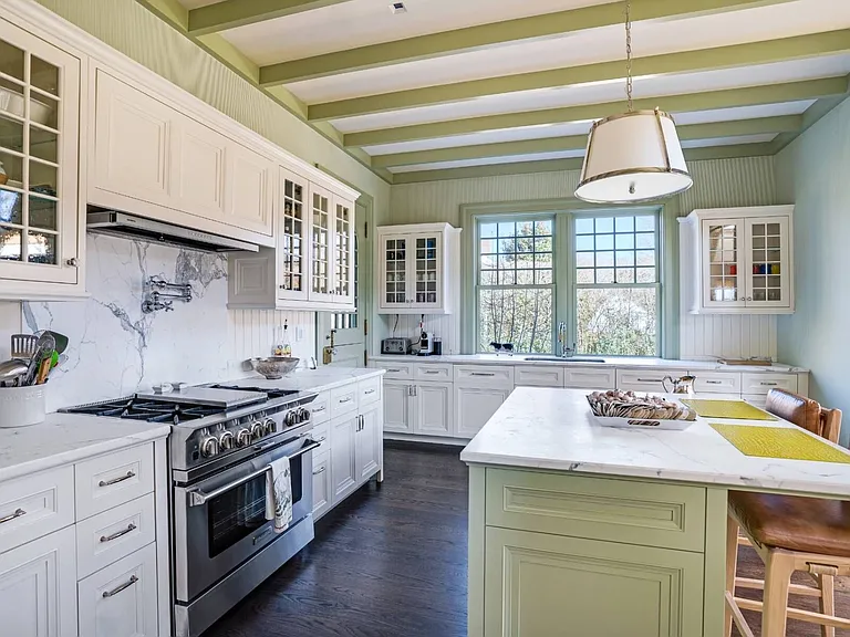 Old money Hamptons estate 134 Herrick Rd in Southampton New York, modern country style kitchen with green island and wood beams