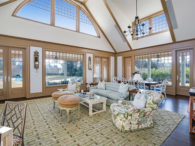 Old money Hamptons estate 134 Herrick Rd in Southampton New York, interior sitting and sun room with vaulted ceilings and floral furnishings a la coastal grandma