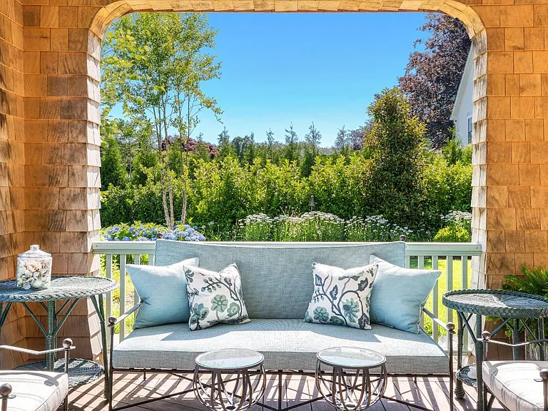 Old money Hamptons estate 134 Herrick Rd in Southampton New York, exterior sitting room with lush landscape views