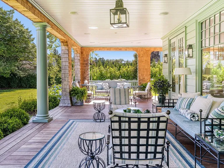 Old money Hamptons estate 134 Herrick Rd in Southampton New York, exterior sitting room with lush landscape views