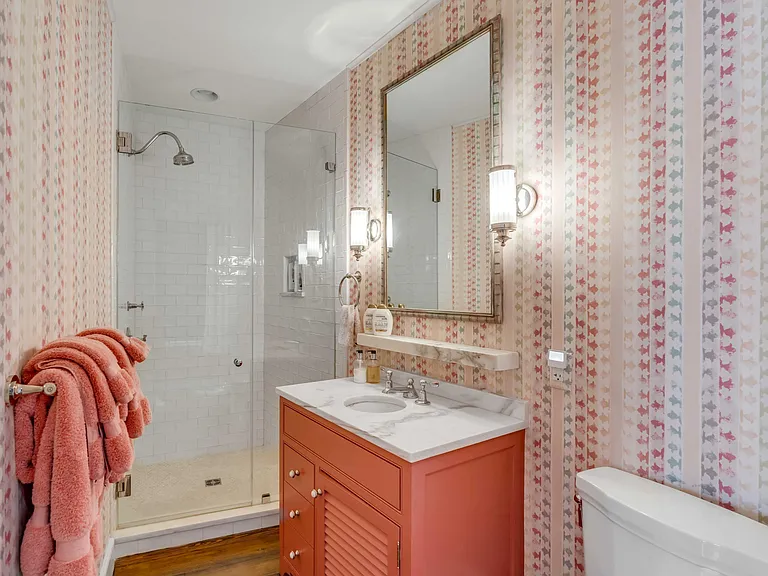 Scott Bessent's Charleston Waterfront Mansion, guest suite bathroom with luxury printed wallpaper and red and white vanity