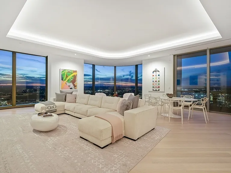 Boston's Most Expensive Penthouse Apartment, curved glass windows and round sofas overlooking the city of Boston from the 58th floor