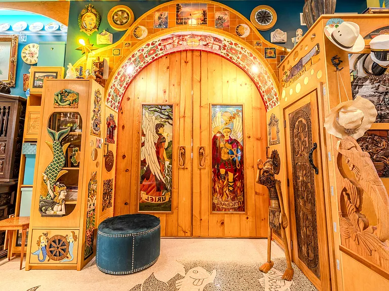 Crazy Florida mansion located at 1201 Marble Way in Boca Raton, interior eclectic foyer with artwork and mosaic staircase and massive hand-carved double doors