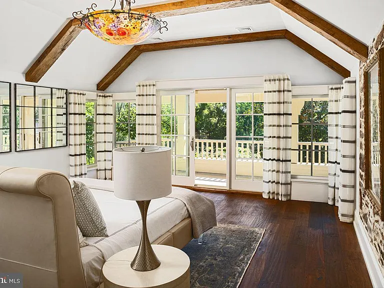 1700s equestrian estate in Lower Gwynedd Pennsylvania, colonial era       master bedroom with exposed beams and modern furniture