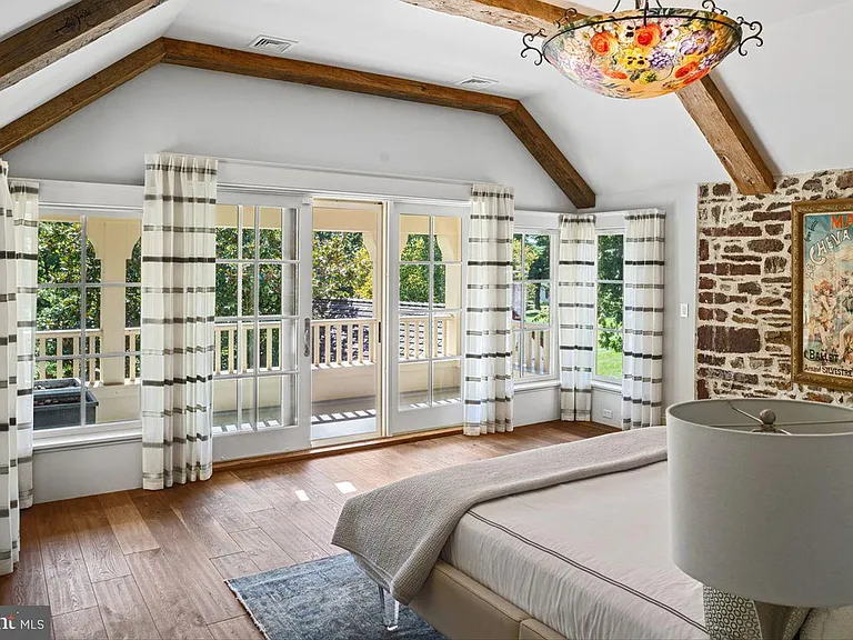 1700s equestrian estate in Lower Gwynedd Pennsylvania, colonial era       master bedroom with exposed beams and modern furniture