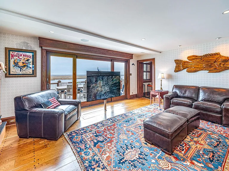 Timeless NJ bayfront beach house, classic den and living room with leather and wood touches of 612 S Bayview Drive in Strathmere, New Jersey