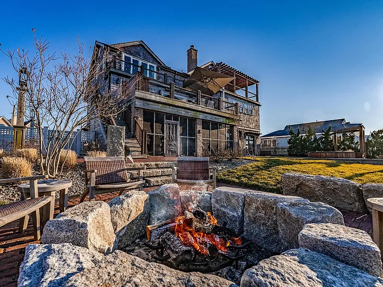 Timeless NJ bayfront beach house, deepwater dock and 24,000 pound boat lift of 612 S Bayview Drive in Strathmere, New Jersey with masonry firepit